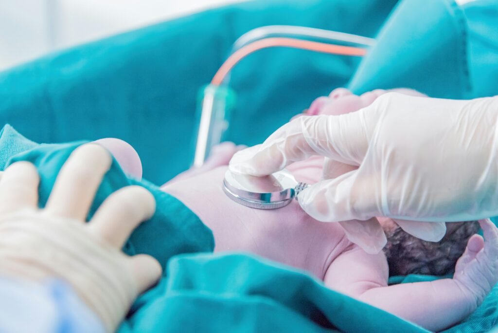 pexels-photo-14751439-14751439 Medical professional examining a newborn baby with a stethoscope in a hospital setting.
