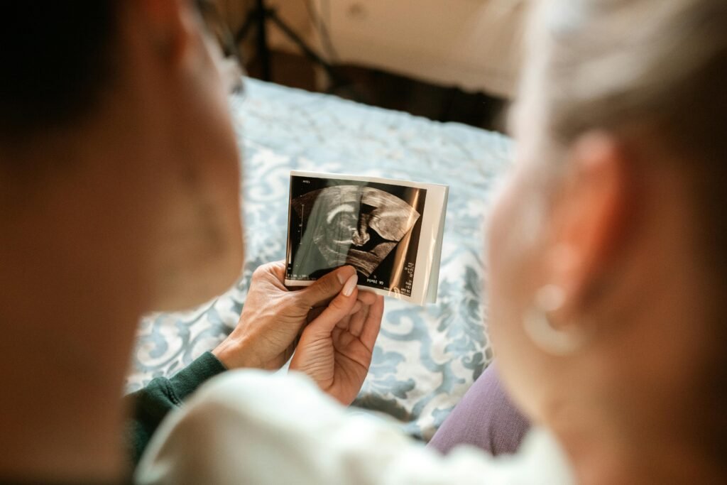 pexels-photo-6149306-6149306 Expectant parents sharing a tender moment viewing their baby's ultrasound image.