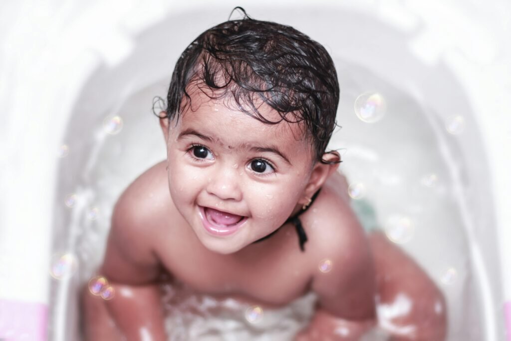 pexels-photo-8207319-8207319 Adorable baby enjoying a bath with bubbles, showcasing a joyful smile and playful expression.