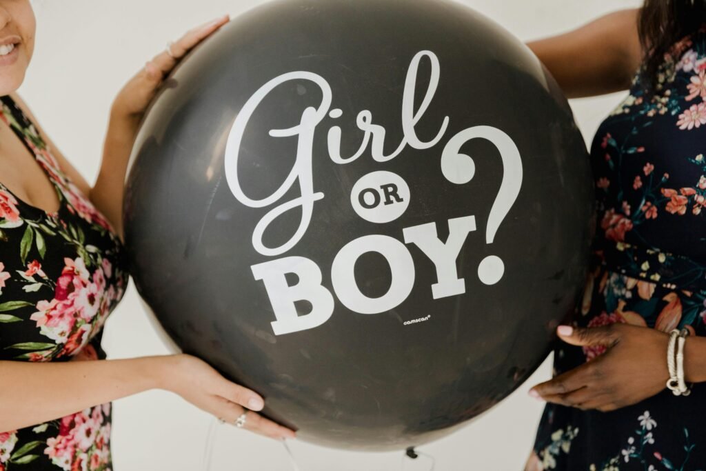 Gender reveal celebration featuring a black balloon with the text 'Girl or Boy?'